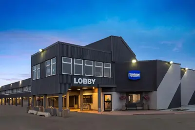 a large black building with a lodyney sign on it at Travelodge by Wyndham Grande Prairie in Grande Prairie