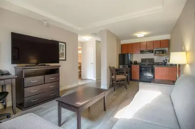 a large living room with a couch and a kitchen at Coast Calgary Downtown Hotel & Suites by APA in Calgary