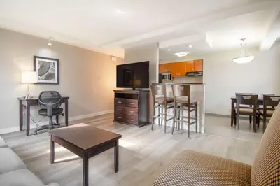 a living room with a couch and a table and chairs at Coast Calgary Downtown Hotel & Suites by APA in Calgary