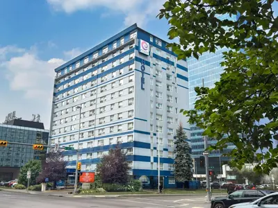 a tall blue building on a city street at Coast Calgary Downtown Hotel & Suites by APA in Calgary