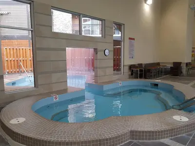 a large swimming pool in a building with a pool at Paradise Resort Club and Spa in Canmore