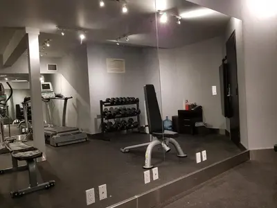 a room with a gym with a chair and weights at Paradise Resort Club and Spa in Canmore