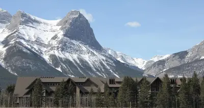 a building in front of a snow covered mountain at Paradise Resort Club and Spa in Canmore