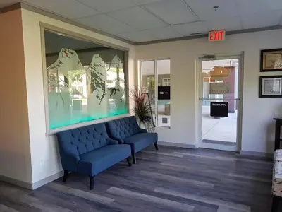a waiting room with a blue couch and a exit sign at Paradise Resort Club and Spa in Canmore