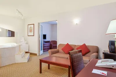 a living room with a couch and a table at Ramada by Wyndham Red Deer Hotel & Suites in Red Deer