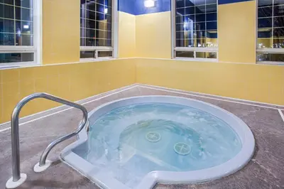 a jacuzzi tub in a bathroom with yellow tiles at Ramada by Wyndham Red Deer Hotel & Suites in Red Deer