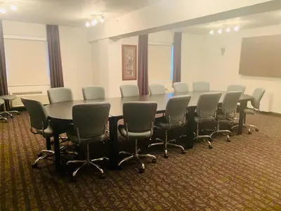 a conference room with a long table and chairs at Ramada by Wyndham Red Deer Hotel & Suites in Red Deer