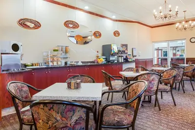 a dining room with tables and chairs in a restaurant at Ramada by Wyndham Red Deer Hotel & Suites in Red Deer
