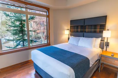 a bedroom with a large bed and two windows at Stoneridge Mountain Resort in Canmore