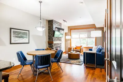 a dining room and living room with a table and chairs at Stoneridge Mountain Resort in Canmore