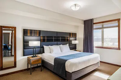 a hotel room with a large bed and a window at Stoneridge Mountain Resort in Canmore