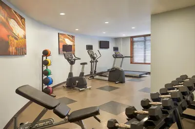 a gym with treadmills and exercise equipment in a room at Stoneridge Mountain Resort in Canmore