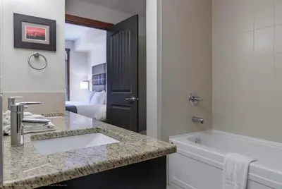 a bathroom with a sink and a bathtub and a bathroom with a toilet at Stoneridge Mountain Resort in Canmore