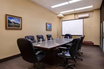 a conference room with a table and chairs and a whiteboard at Days Inn by Wyndham Calgary South in Calgary