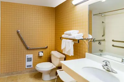 a bathroom with a toilet and a sink and a mirror at Econo Lodge Inn & Suites University in Calgary