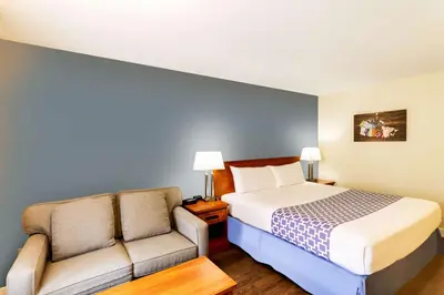 a hotel room with a bed and a couch at Econo Lodge Inn & Suites University in Calgary