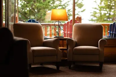 two chairs and a lamp in front of a window at Overlander Mountain Lodge in Jasper