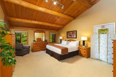 a bedroom with a bed and a wooden ceiling at Overlander Mountain Lodge in Jasper