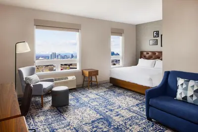 a hotel room with a bed and a chair and a window at Four Points by Sheraton Calgary Airport in Calgary