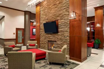 a lobby with a fireplace and a tv on a brick wall at Four Points by Sheraton Calgary Airport in Calgary
