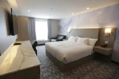 a hotel room with a bed and a desk at Days Inn by Wyndham Calgary North Balzac in Balzac