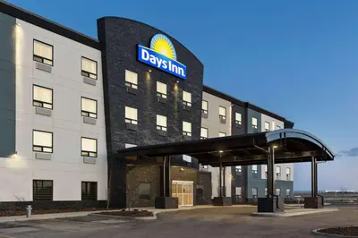 a building with a davis inn sign on it at Days Inn by Wyndham Calgary North Balzac in Balzac