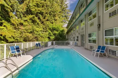 a house with a swimming pool and two chairs at Four Points by Sheraton Surrey in Surrey