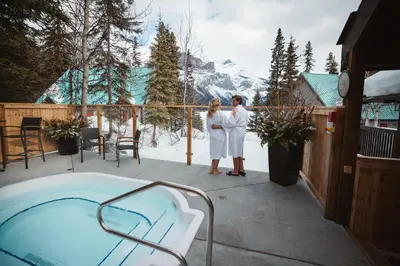 a couple standing on a deck next to a hot tub at Emerald Lake Lodge in Field