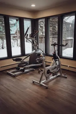 a gym with two exercise bikes in a room with windows at Emerald Lake Lodge in Field