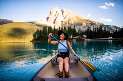 a woman paddling a kayak on a lake at Emerald Lake Lodge in Field