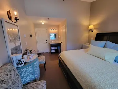 a bedroom with a large bed and a table and a chair at The Georgetown Inn in Canmore