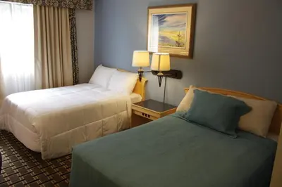a hotel room with two beds and a window at Hillcrest Motel in Swan Hills
