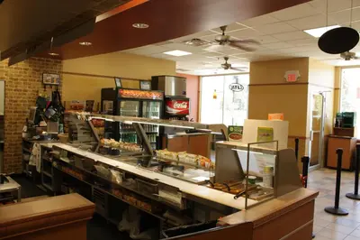a fast food restaurant with a counter with food at Hillcrest Motel in Swan Hills