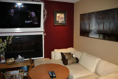 a living room with a white couch and a flat screen tv at Hillcrest Motel in Swan Hills