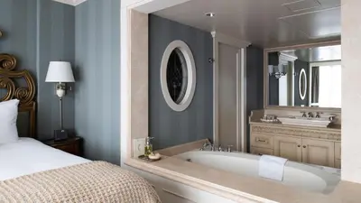 a bathroom with a tub and a bed and a mirror at Wedgewood Hotel & Spa - Relais & Chateaux in Vancouver