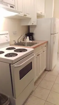 a kitchen with a white stove and a sink at Western Budget Motel Bonnyville in Bonnyville
