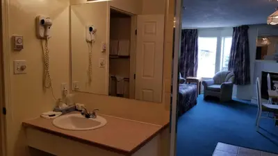 a bathroom with a sink and a phone in a room at Western Budget Motel Cold Lake in Cold Lake