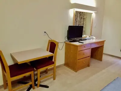 a room with a desk with a computer on top of it at New Imperial Inn in Cold Lake
