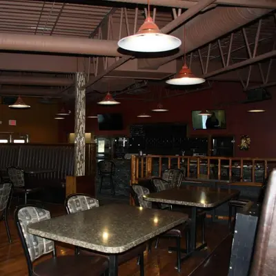 a dining room with tables and chairs and lights at New Imperial Inn in Cold Lake