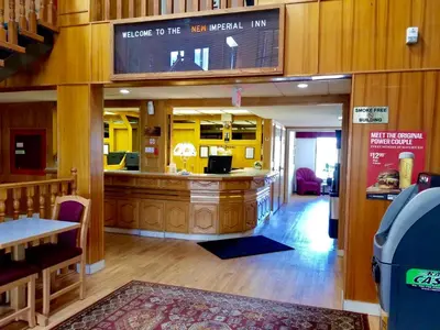 a restaurant with a counter in the middle of a room at New Imperial Inn in Cold Lake