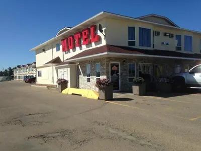 a hotel with a sign on the front of it at Western Budget Motel Peace River in Peace River