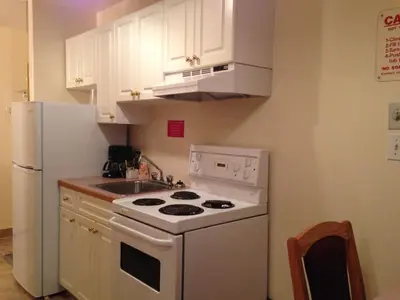 a kitchen with a white stove and a white refrigerator at Western Budget Motel Peace River in Peace River