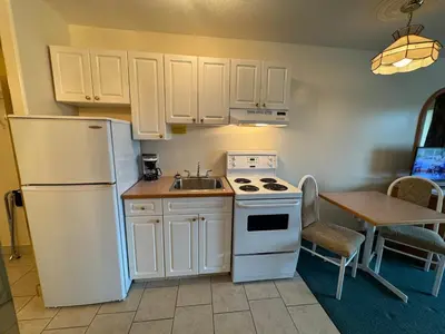 a kitchen with a white refrigerator and a sink at Western Budget Motel #3 Whitecourt in Whitecourt