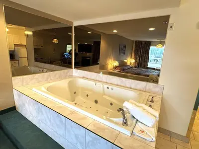a large bath tub in a bathroom with a large mirror at Western Budget Motel #3 Whitecourt in Whitecourt