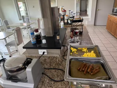 a kitchen counter with a tray of eggs and sausage at Western Budget Motel #3 Whitecourt in Whitecourt