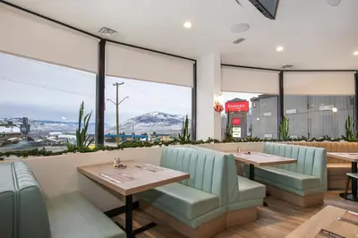 a restaurant with two tables and a view of the mountains at Ramada by Wyndham Kamloops in Kamloops