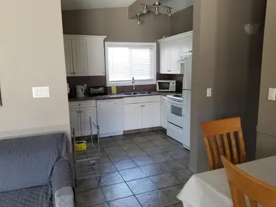 a small kitchen with white cabinets and a table at Osoyoos Lakeview Inn & Suites in Osoyoos