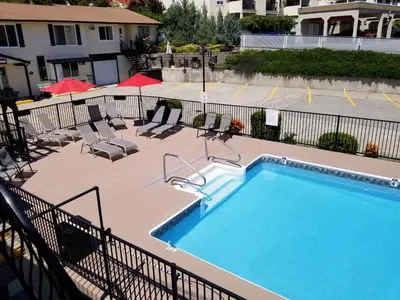 a swimming pool at a hotel with chairs and a swimming pool at Osoyoos Lakeview Inn & Suites in Osoyoos