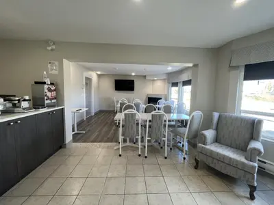 a kitchen and dining room with a table and chairs at Western Budget Motel #1 & 2 Whitecourt in Whitecourt
