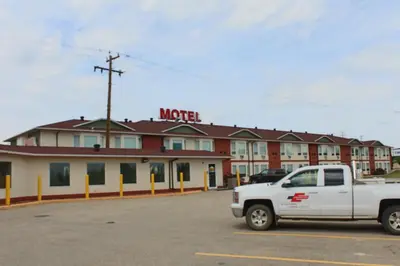 a white truck parked in front of a motel at Western Budget Motel #1 & 2 Whitecourt in Whitecourt
